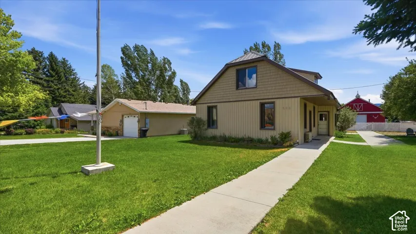 Exterior featuring horizontal siding, upper-level shake siding, a metal roof, and a concrete pathway