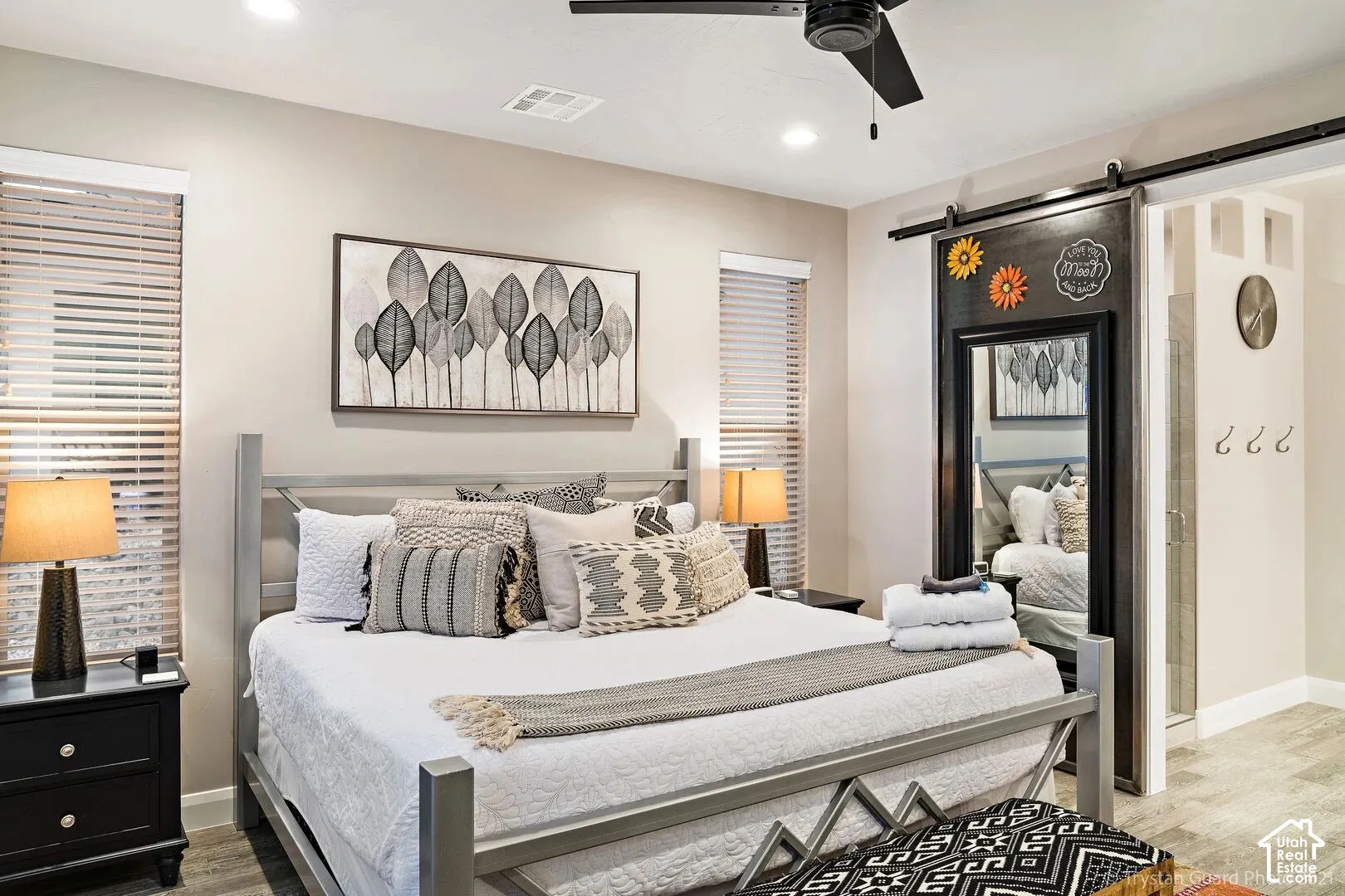 Recessed lighting, wood-finish flooring, a ceiling fan, and a barn door with mirror