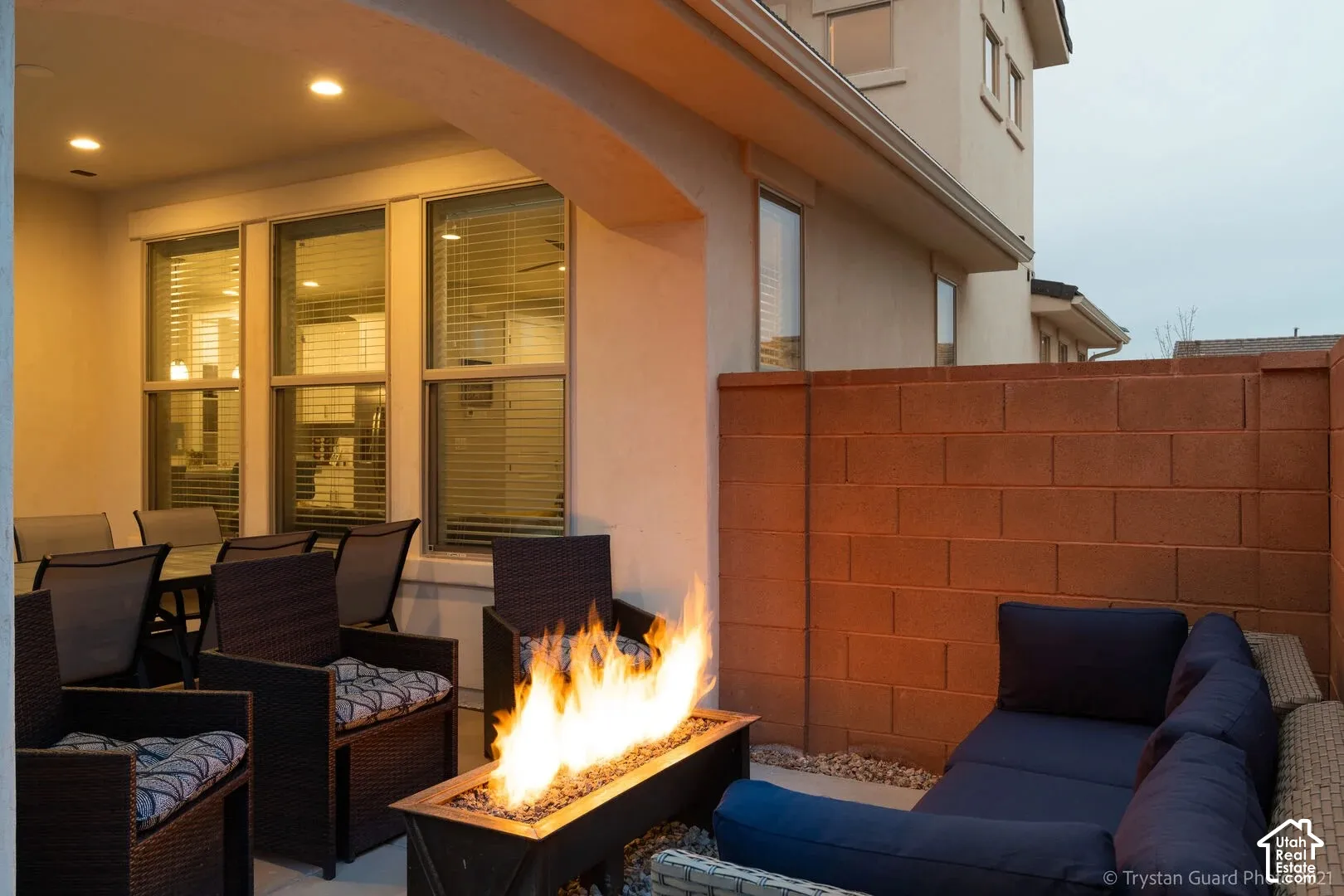 Covered patio with recessed lighting, multiple windows, and a privacy wall