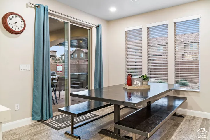 Sliding glass door, recessed lighting, three paneled windows, window blinds, and tile flooring