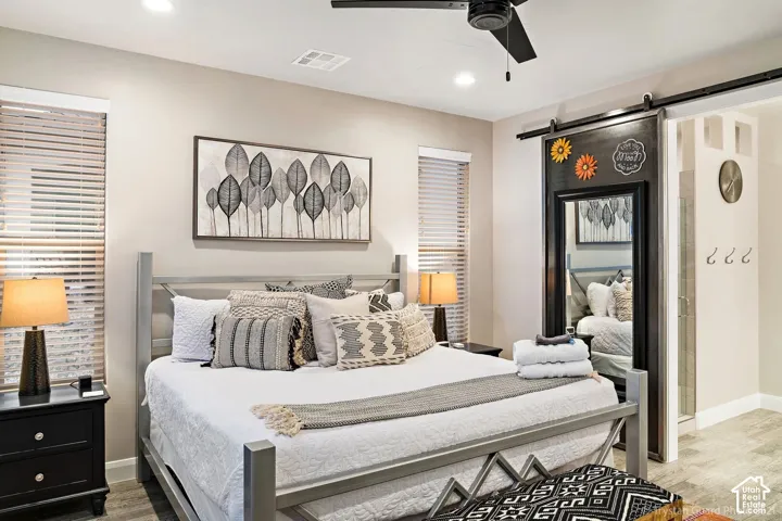 Recessed lighting, wood-finish flooring, a ceiling fan, and a barn door with mirror
