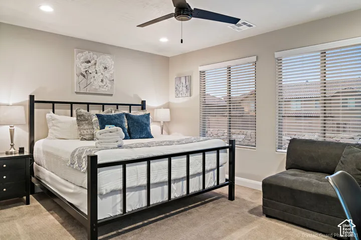Recessed lighting, ceiling fan, carpeted flooring, and two windows with blinds