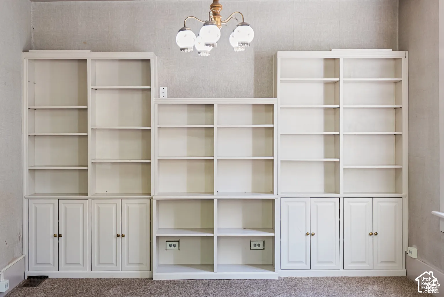 Built-in shelving units feature multiple open shelves and lower cabinet storage