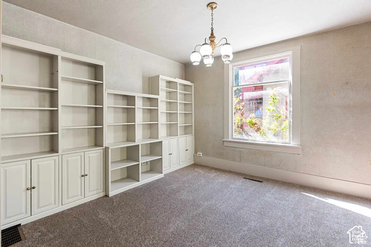 Built-in white cabinetry, integrated shelving, and a large window with white trim