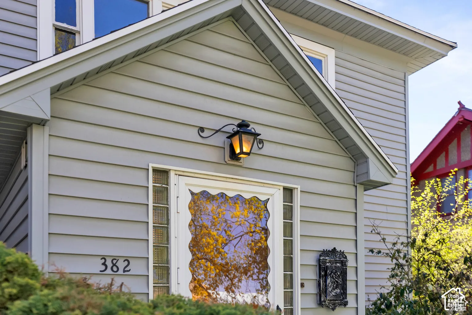 Exterior featuring horizontal siding, a decorative outdoor sconce, and a front entry with glass block sidelites