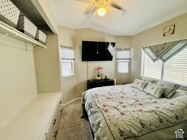 Built-in storage bench with multiple drawers, wall-mounted shelving, multiple windows with blinds, and a ceiling fan with integrated lighting