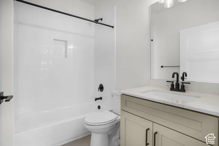 White subway tile shower surround with a built-in niche, matte black fixtures, and a light-toned vanity with an integrated sink and countertop