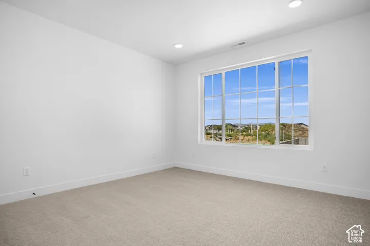 2nd bedroom -White walls, recessed lighting, carpet flooring, and a large window with multiple panes