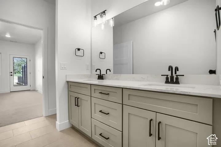 primary Dual vanity with light-toned cabinetry, matte black hardware, and an integrated rectangular sink