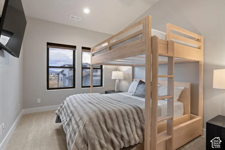 Recessed lighting, carpet flooring, and two dark-framed windows