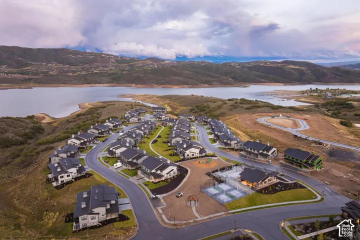 Lakeside residential development featuring multiple housing units, paved roads, and recreational courts