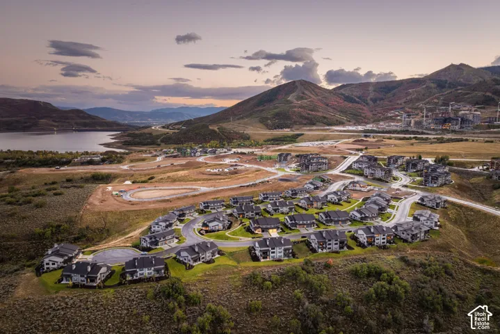 Expansive community with varied architectural styles, manicured landscaping, and mountainous terrain