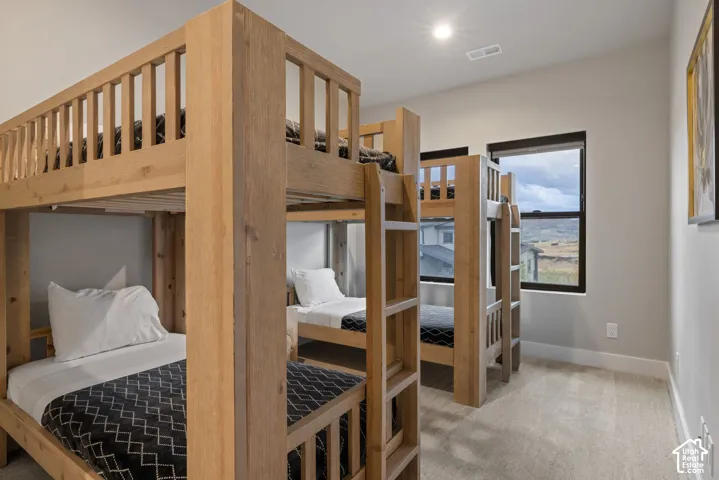 Carpeted flooring, contemporary bunk beds, recessed lighting, and a large window with a dark frame