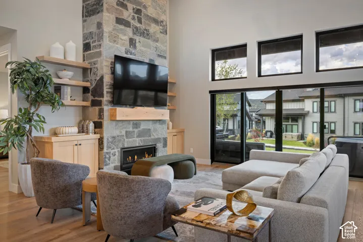 Stone-clad fireplace with built-in gas insert, wood mantel, and integrated open shelving