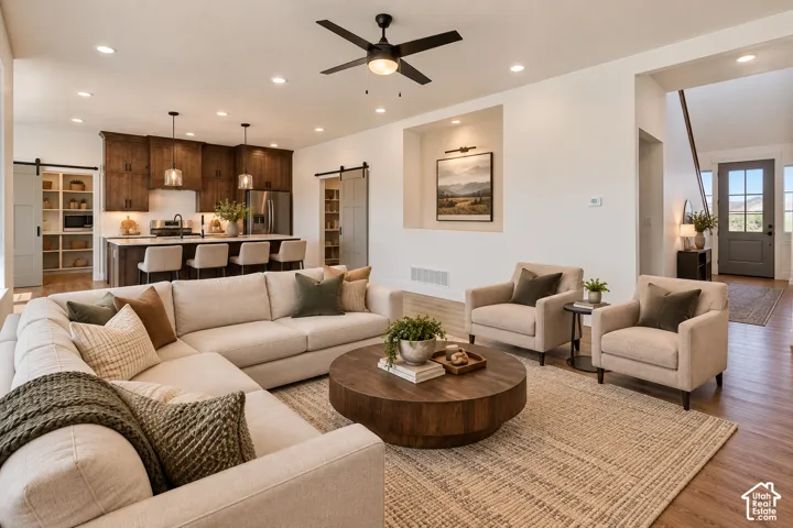 Open-concept living space featuring wood-finish flooring, a contemporary ceiling fan, and recessed lighting