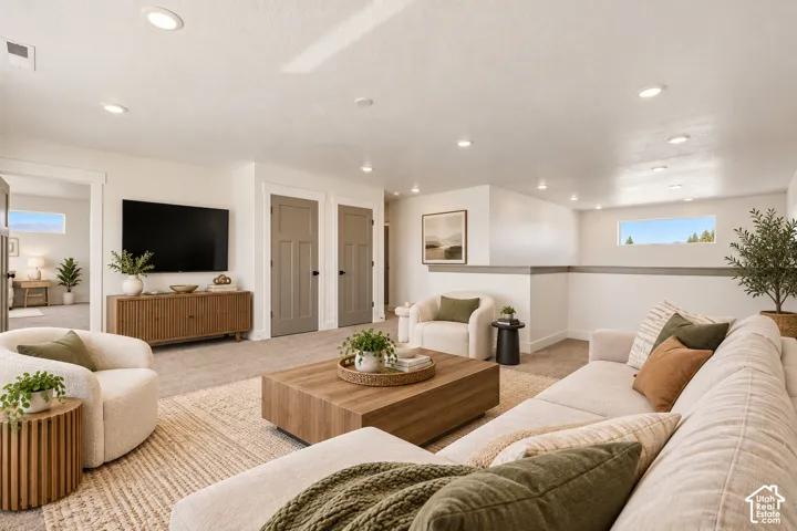 Recessed lighting, wood-finish media console, neutral carpeting, horizontal window, and panel doors