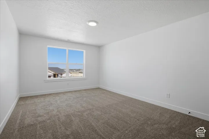 Neutral wall color, recessed ceiling lighting, light-colored carpet, large window, white trim