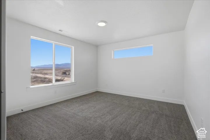 Recessed ceiling lighting, a large picture window, a high horizontal window, and gray carpet