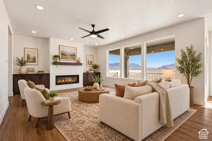 Spacious living area featuring wood-finish flooring, a linear fireplace with a mantel, and built-in cabinetry