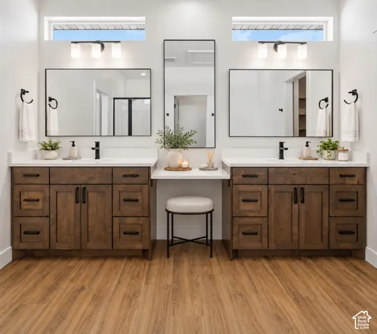Dual wood-finish vanities with white countertops and black hardware