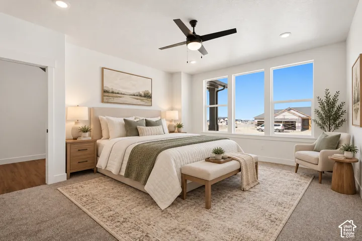 Recessed ceiling lighting, ceiling fan, three large pane windows, and neutral carpeting
