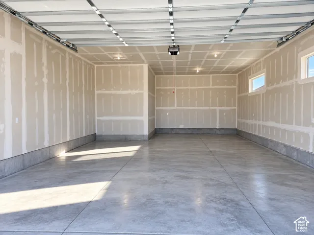 Spacious garage featuring a concrete floor, two windows providing natural light, and recessed lighting