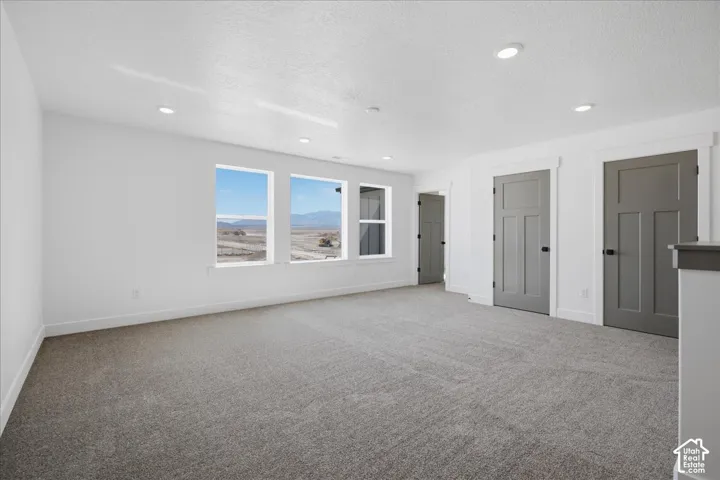 Bright interior space featuring recessed lighting, a multi-pane window configuration, and gray panel doors