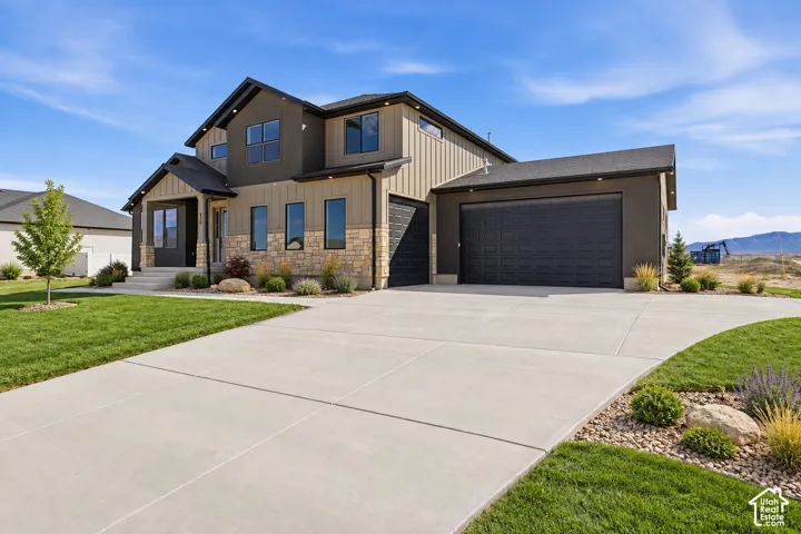 Contemporary exterior with stone accents, vertical siding, and a gabled roofline