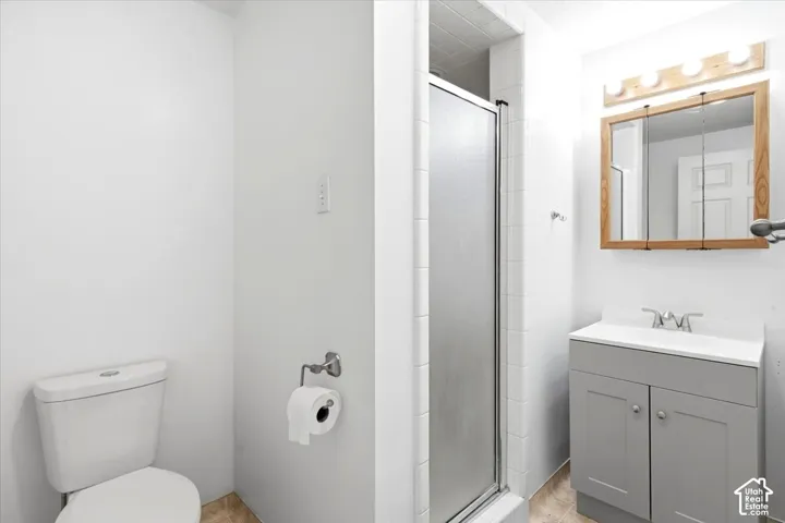 Modern vanity with a white countertop, chrome fixtures, and wood-framed mirror