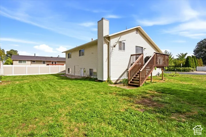Expansive lawn area with a composite privacy fence and a built-in wooden deck