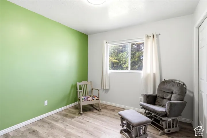 Wood-finish flooring, a window with natural light, and a white interior door