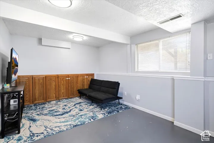 Recessed ceiling lighting, built-in wooden cabinetry, window with blinds, and light gray painted walls