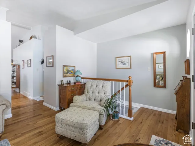 Hardwood flooring, painted walls, white trim, and a wood banister with white spindles
