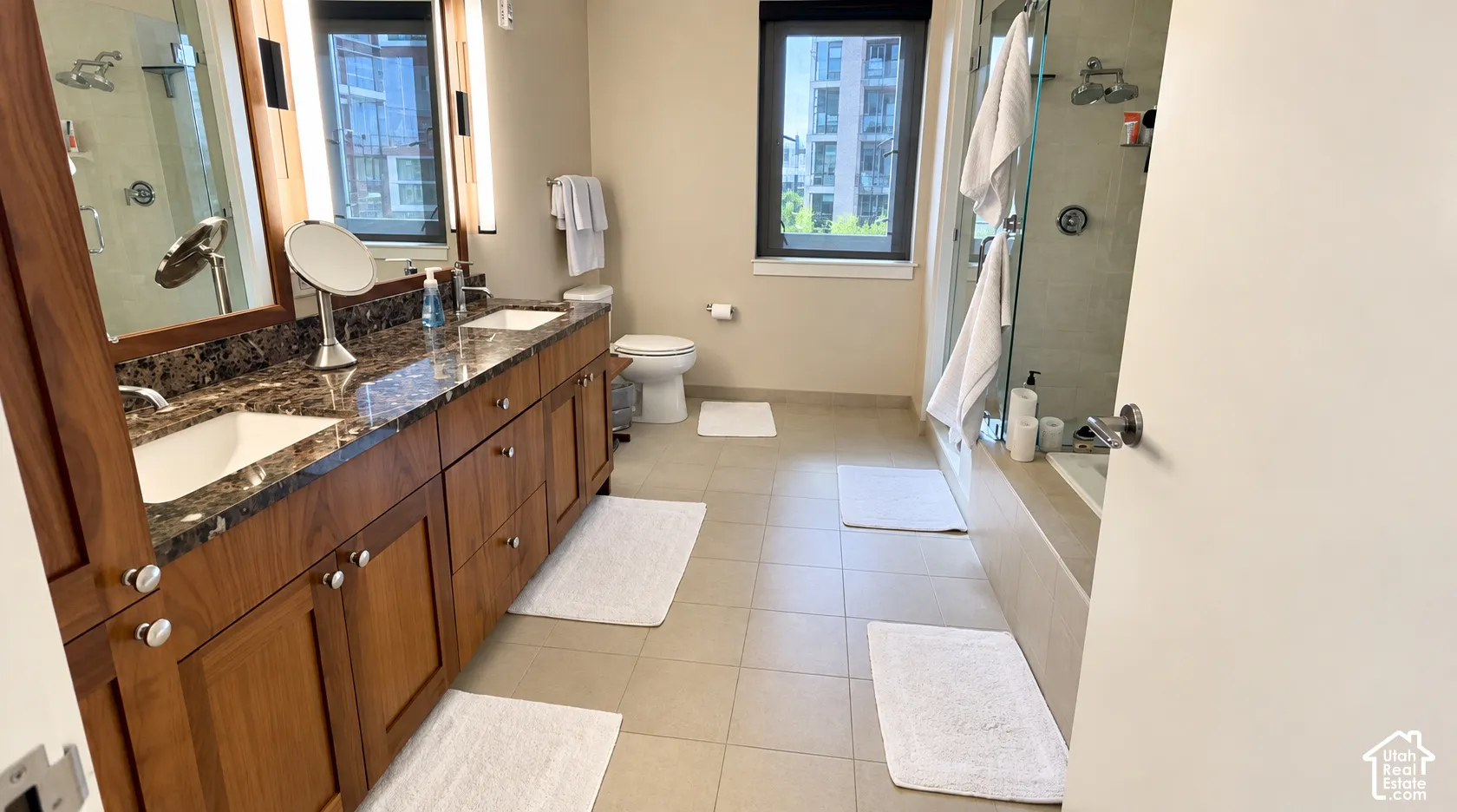 Dual vanity with integrated sinks, dark wood-finish cabinetry, and a dark patterned countertop