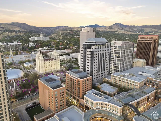 Mountain backdrop, expansive city skyline, prominent urban structures, architectural dome, multiple high-rise buildings