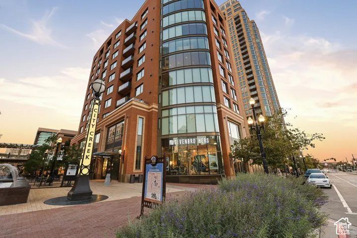 Multi-story building featuring a brick exterior, extensive glass paneling, and private balconies