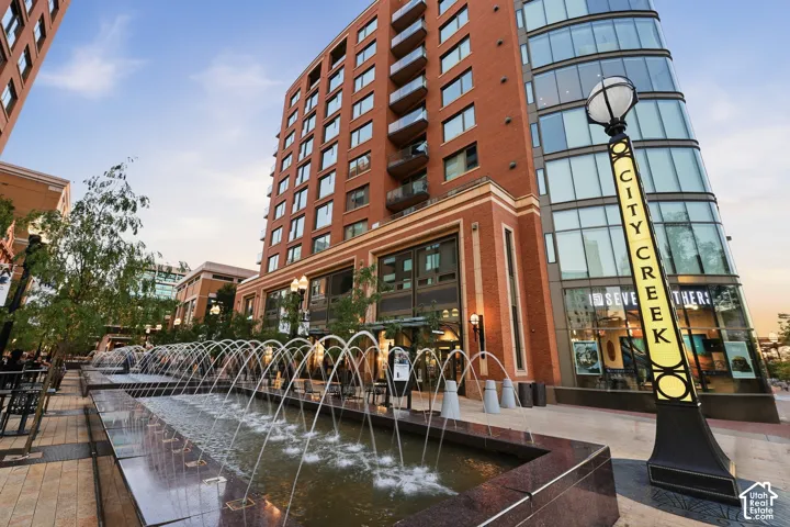 Fountains and mature landscaping complement the brick and glass-paneled building exterior