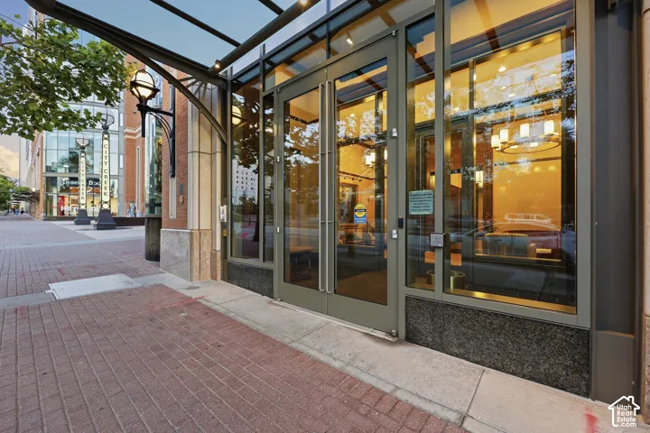 Commercial storefront with expansive glass doors, a glass canopy, and granite-clad exterior details