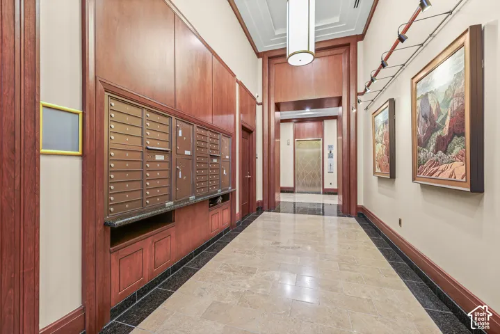 Building entryway featuring wood paneling, a large chandelier, recessed lighting, and tile flooring