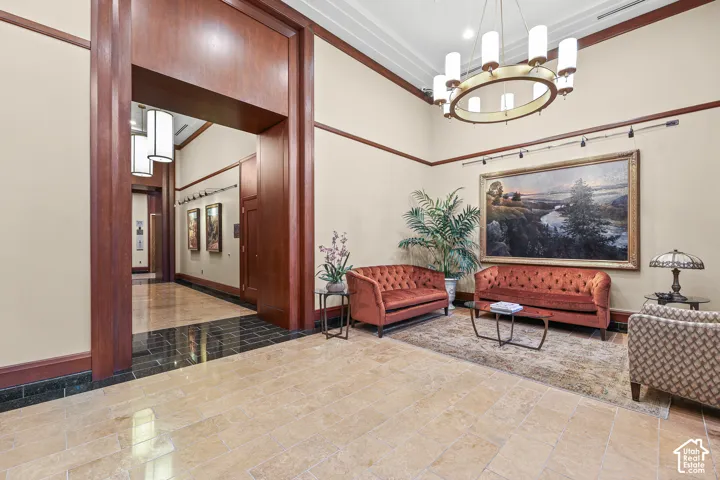 Spacious entryway featuring a decorative chandelier, tall ceilings, and a combination of light and dark stone tile flooring