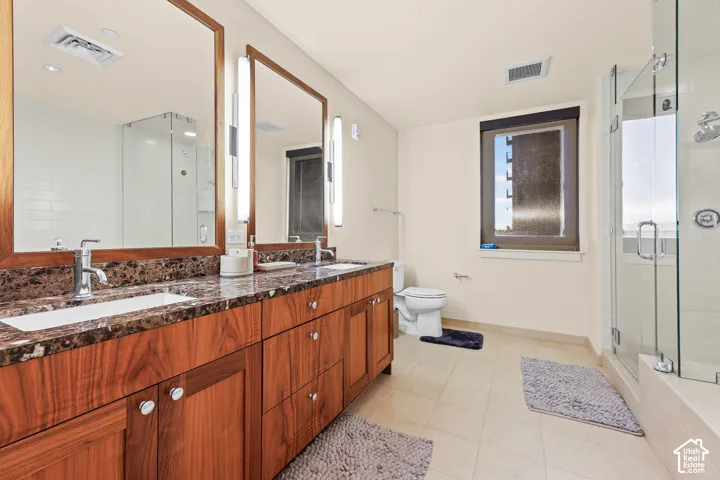 Double vanity with wood cabinetry and stone-finish countertop