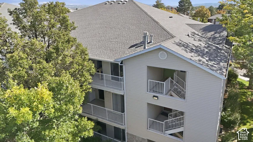 Multi-level building with gray siding and a shingle roof