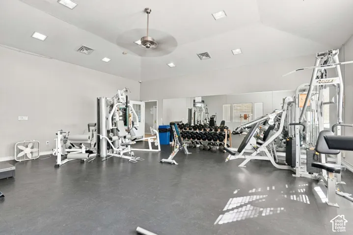 Fitness center with extensive exercise equipment, mirrored wall, recessed lighting, and ceiling fan