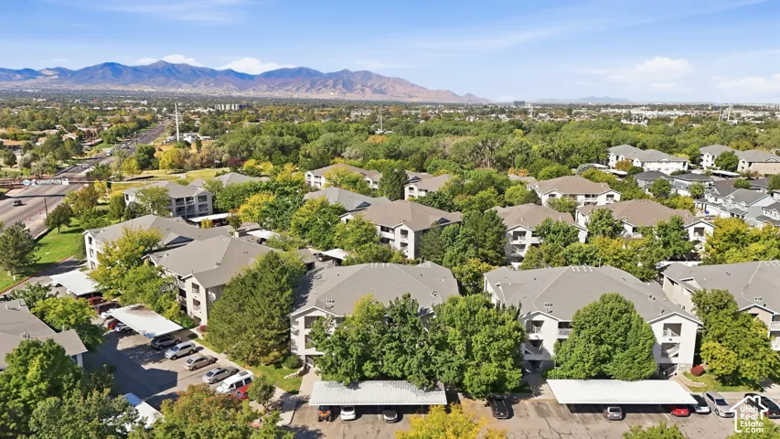 Expansive property featuring multiple multi-story residential buildings, covered parking areas, and mature trees