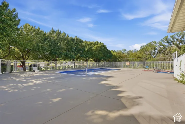 Outdoor pool area featuring a perimeter fence and concrete decking