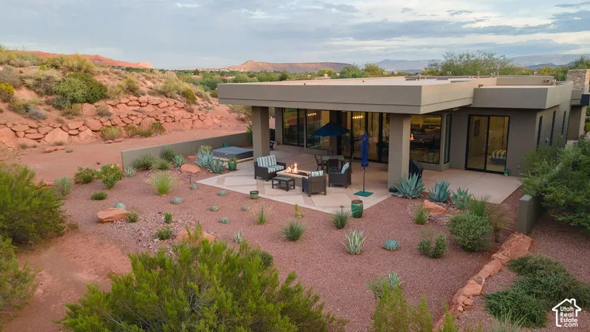 Contemporary exterior featuring a flat roofline, extensive glass doors, a covered patio, and a hot tub