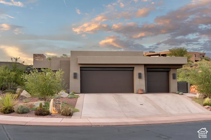 Contemporary exterior with a flat roofline, two integrated garage doors, and a stone house number marker