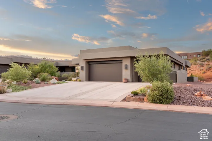 Contemporary exterior with stucco finish, integrated garage, and a concrete driveway