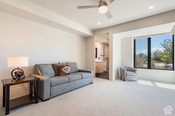 Recessed ceiling lighting, ceiling fan, large window, and light-colored carpeting