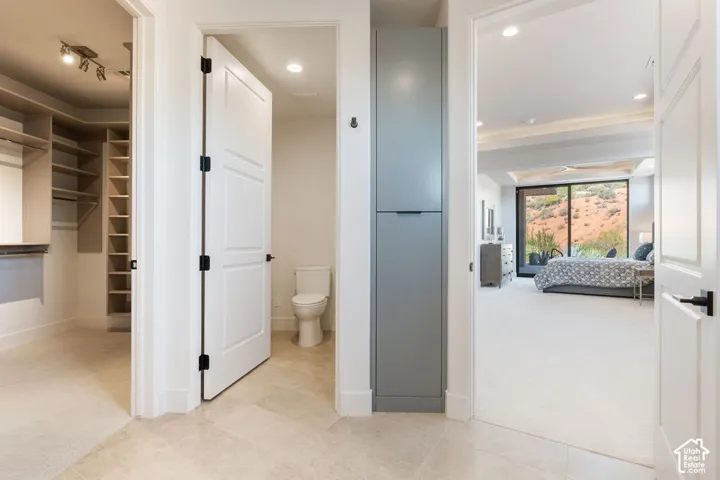 Integrated walk-in closet with built-in shelving, a separate water closet, and built-in storage cabinetry